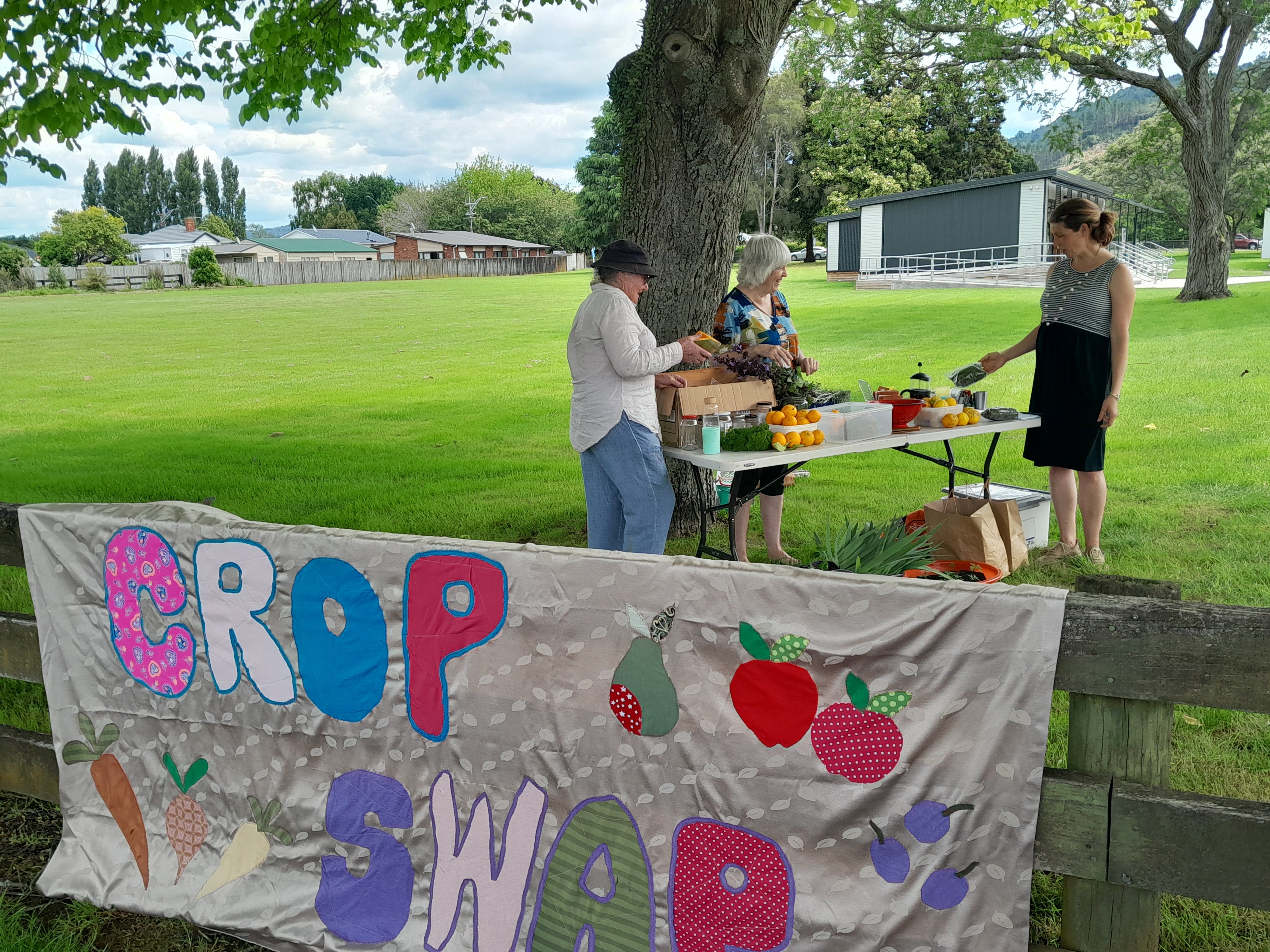 Crop swappers gathered around table of local produce outside Taupiri School.