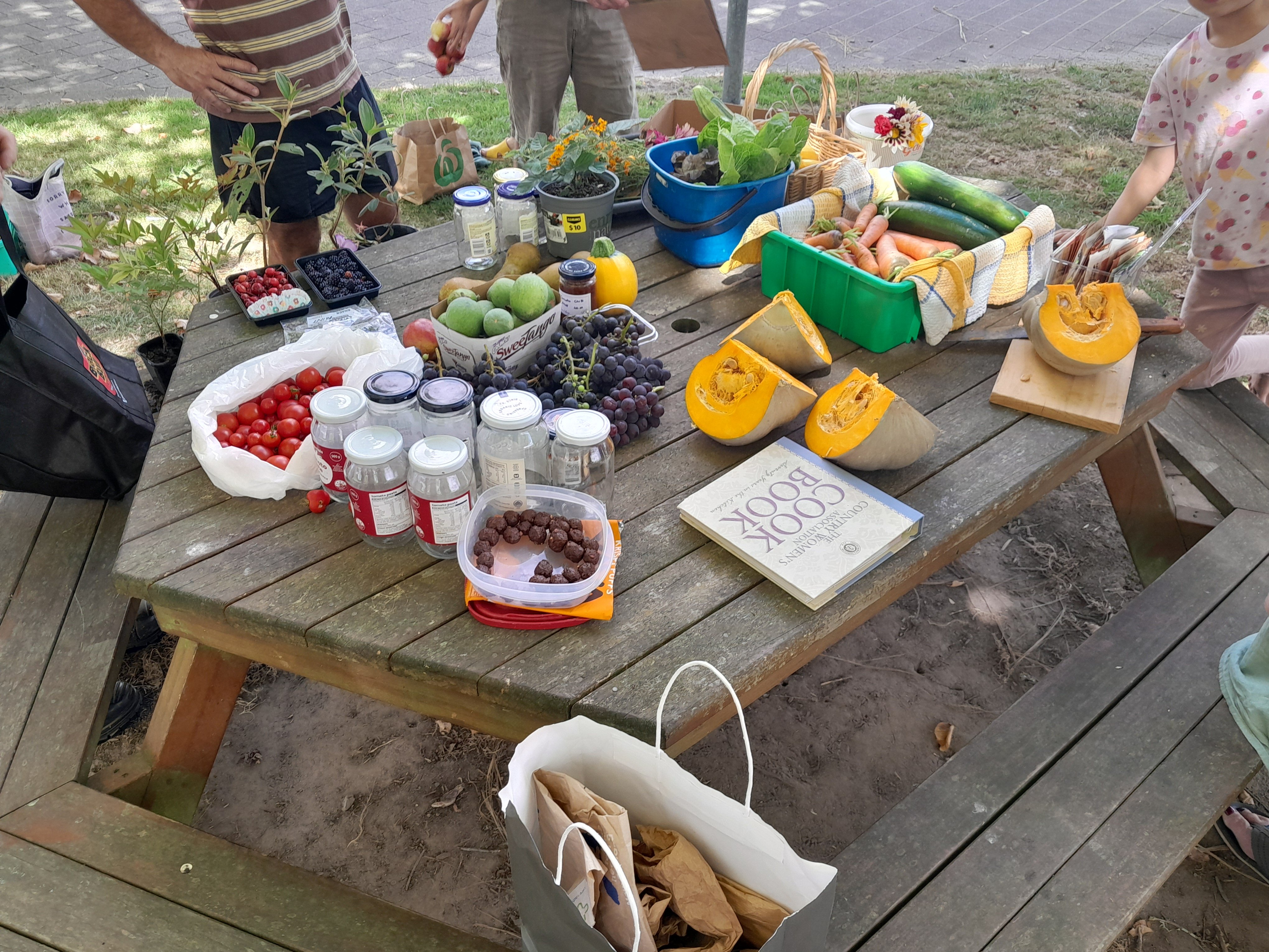 Crop swappers gathered around table of local produce outside Taupiri School.