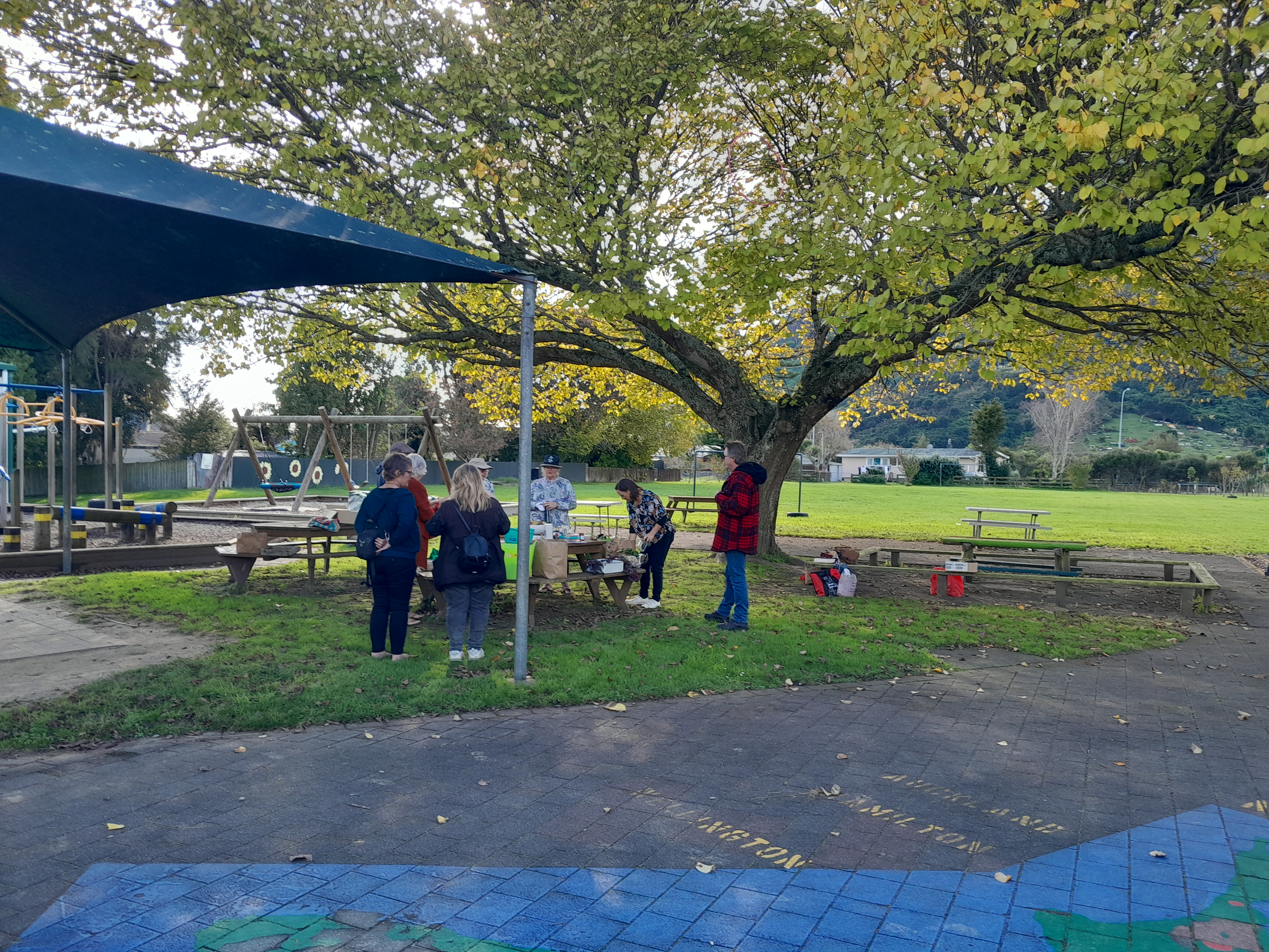 Crop swappers surround a table on Taupiri School grounds.