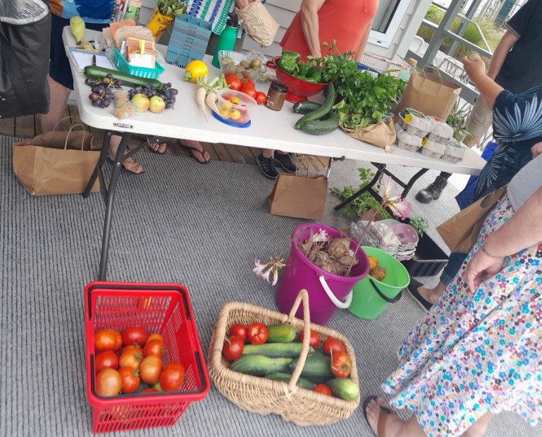 Table overflowing with produce, surrounded by swappers.