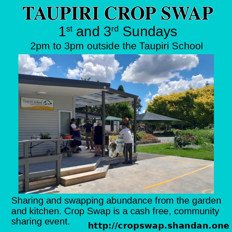 Crop swappers chatting away around a table of produce to swap with scenic Taupiri School grounds in background.